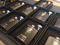 Custom engraved groomsman flasks with tuxedo design and names in gift boxes