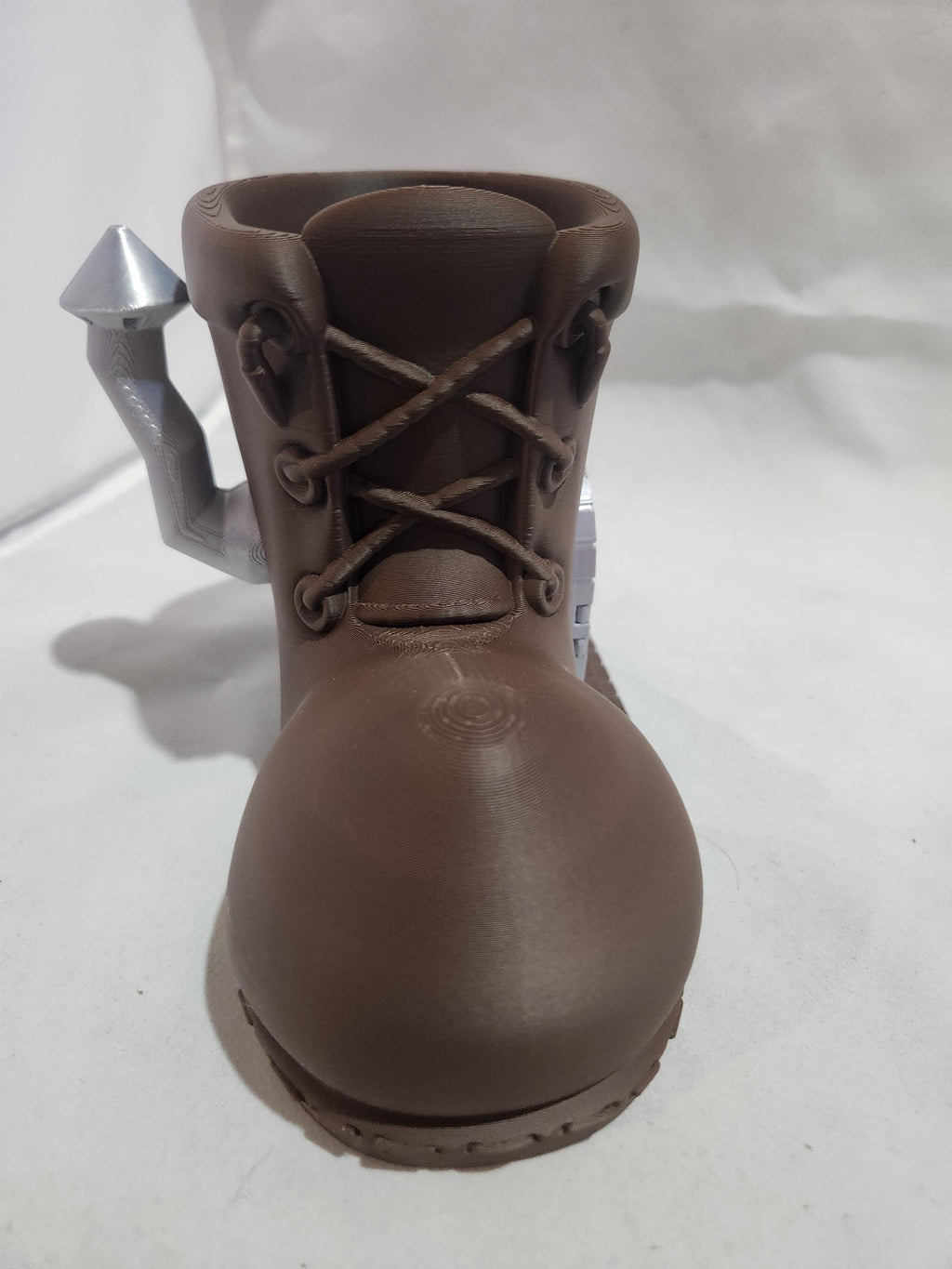 3D printed brown boot-shaped planter with silver spout on white background