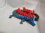 3D printed blue dragon with red Perry's Printing sign and thumbs up on white background