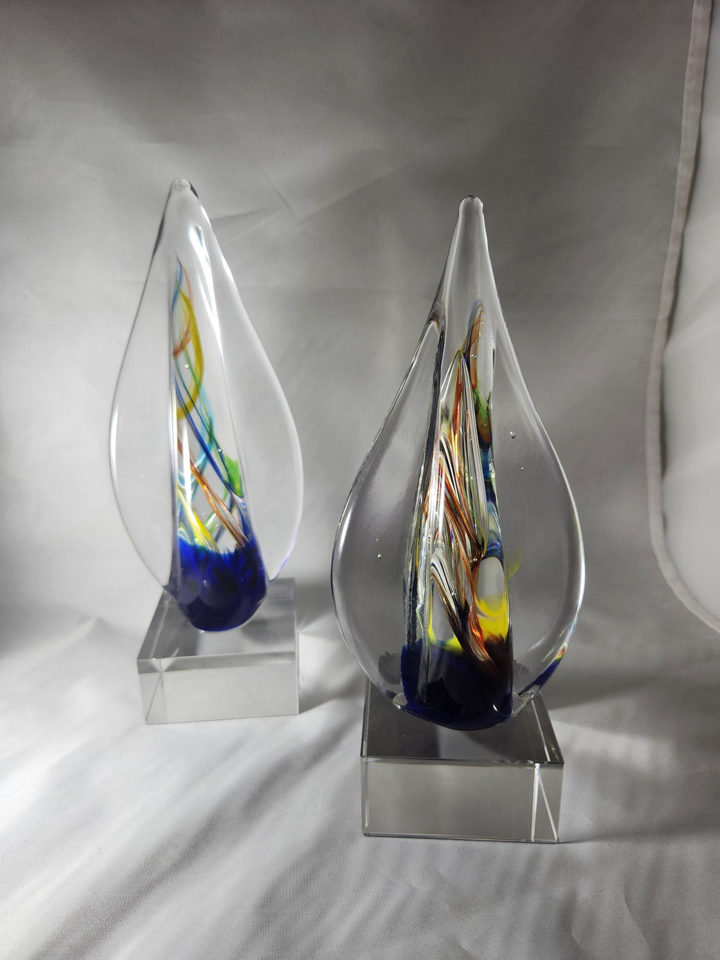 Colorful glass art awards with teardrop shape on clear bases, suitable for custom engraving