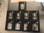 Custom engraved black groomsmen flasks with tuxedo design in gift boxes, wedding party favors.