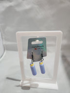 Handmade dangle earrings with light purple and yellow cylindrical design on display card