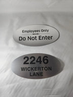 Custom engraved aluminum oval signs for employees only and house address on white background