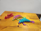 Colorful 3D printed articulated lizard toys and sign on wood table, custom printing display